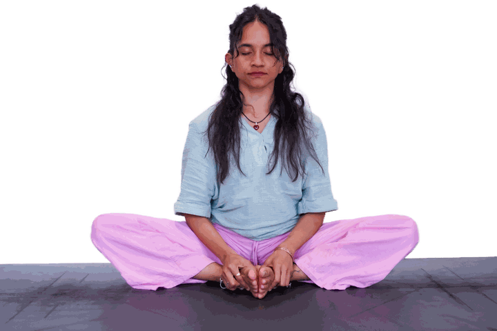 Seated quietly, eyes closed, hands resting