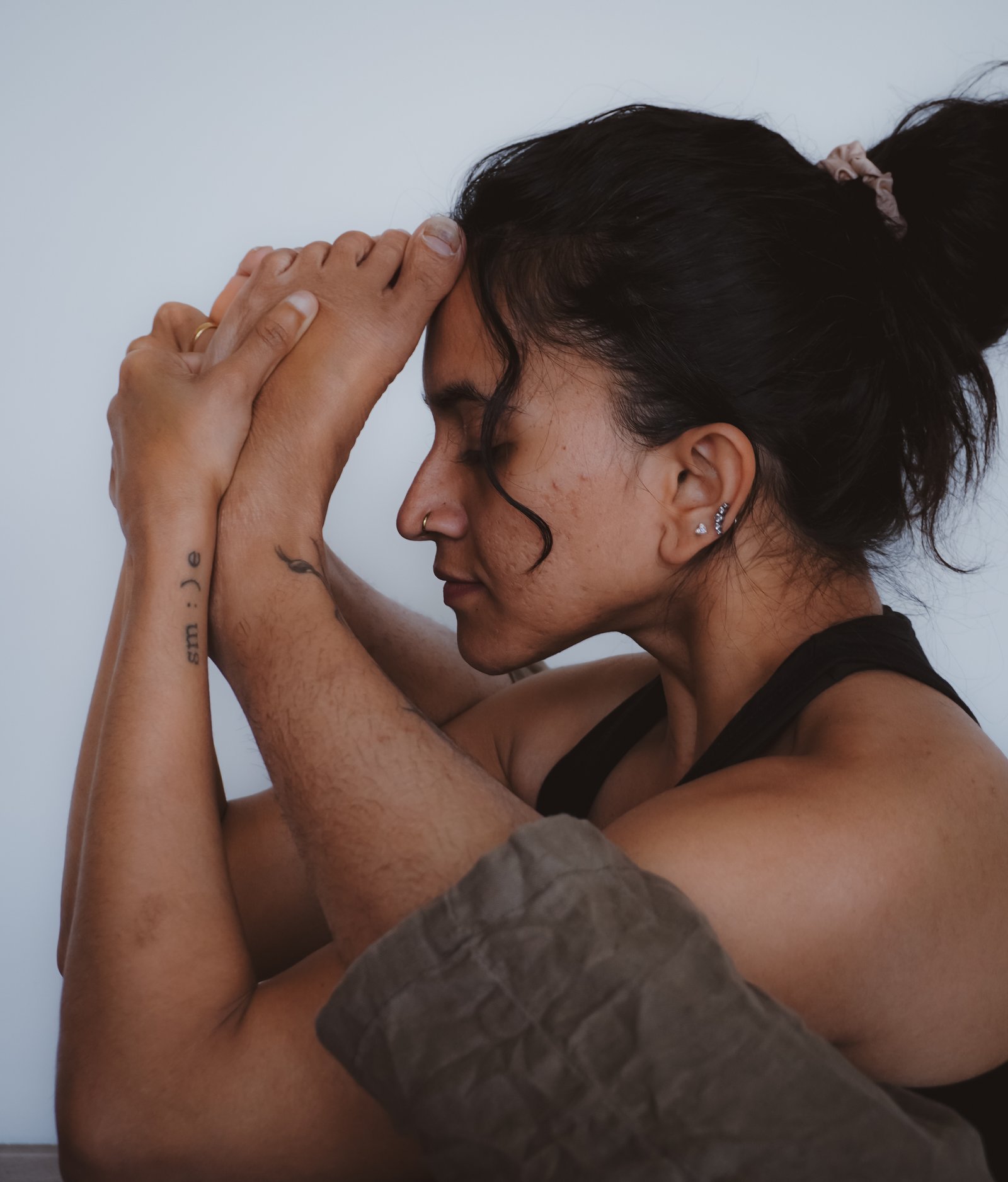 Priyanka in a quiet seated fold, hands gently clasped at her forehead, justnow YOGA, Prague
