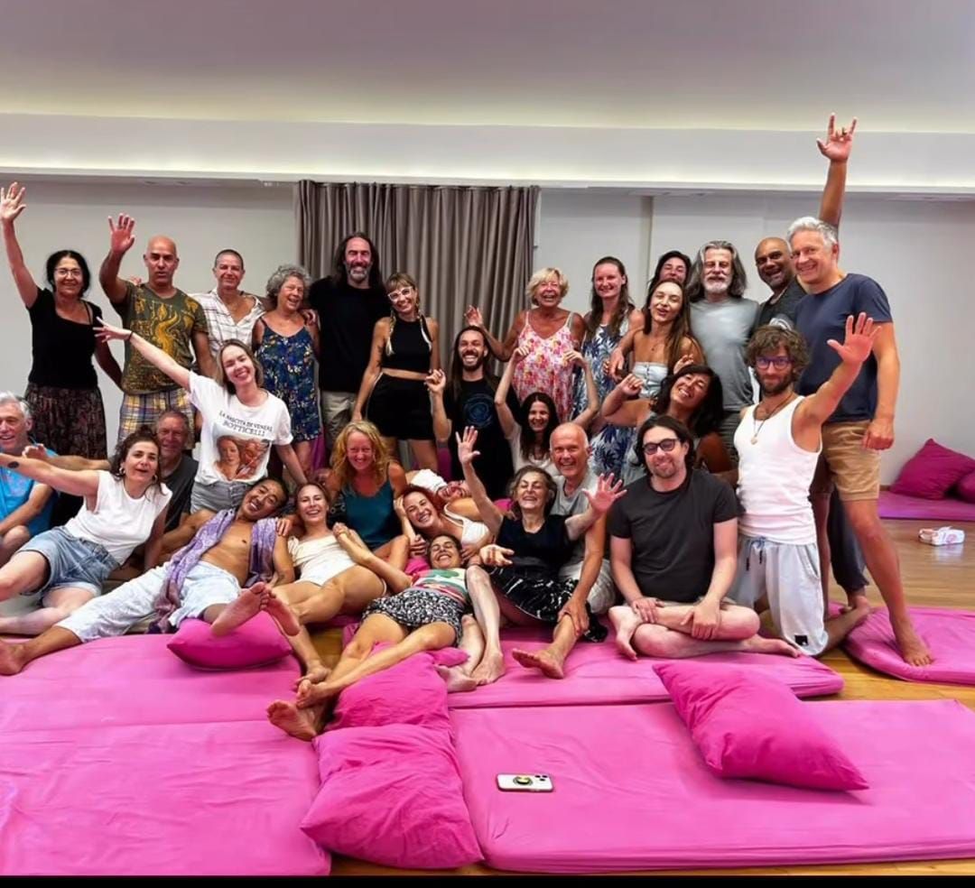 A workshop group laughing together on mats